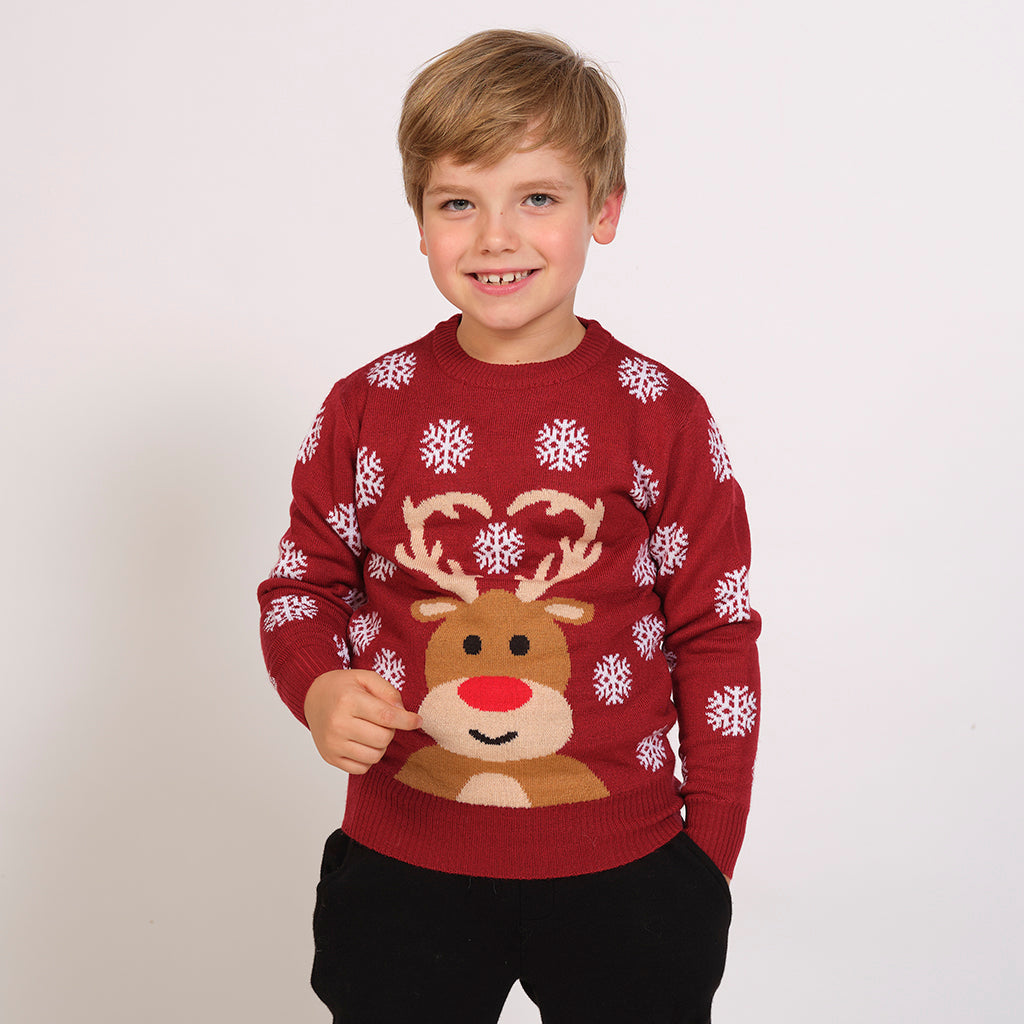 Et barn iført en rød julesweater med et rensdyr på.